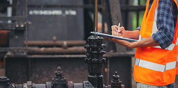 workers-standing-checking-beside-working-oil-pumps.jpg